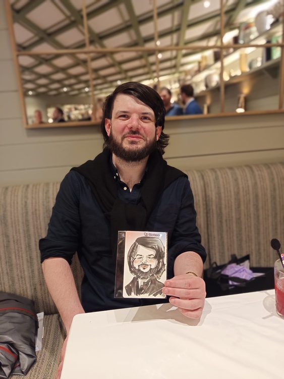 Invitados mostrando sus caricaturas personalizadas en un congreso