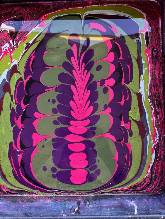 Pintura corporal psicodélica creada mediante marmolado sobre agua